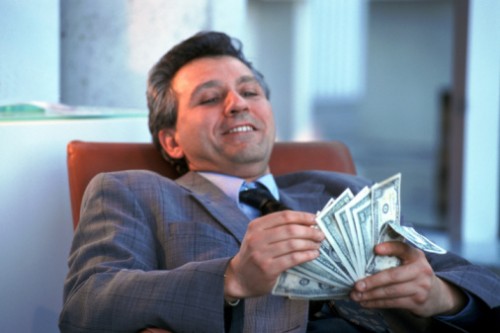 a banker counting profits from credit card interest rates and penalty fees