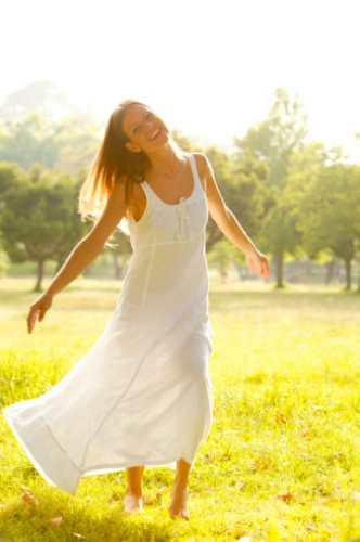 woman dancing on the grass in the sunshine