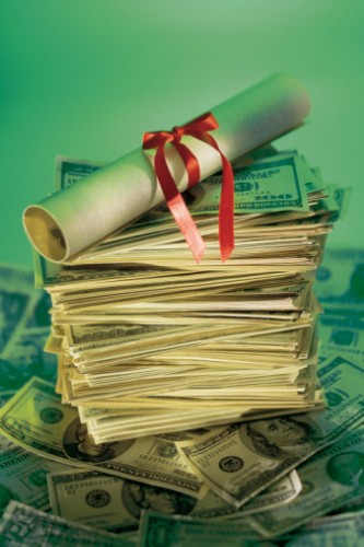a college degree sitting on a pile of money