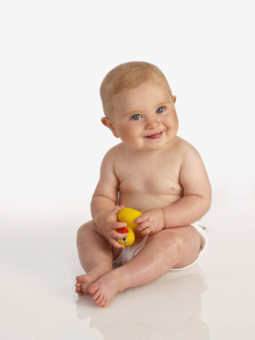 a toddler in diapers smilling at the camera