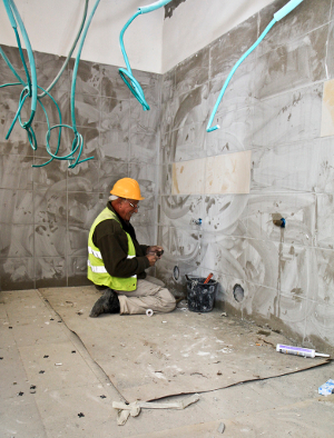 A contractor at work on an interior wall.