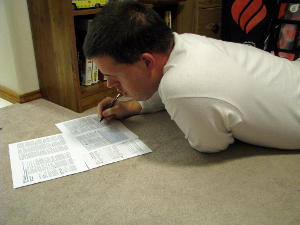 documents_you_need_before_you_die A man lying on the floor as he fills out important tax papers.