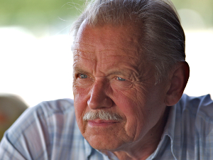 baby_boomer_stock_market A handsome, mustachioed man of the baby boomer generation stares into space, wistfully.