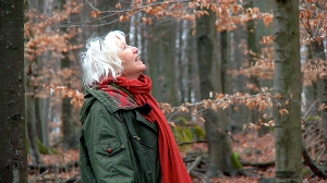 living_without_money Heidemarie Schwermer walks beneath a cover of trees in fall form.