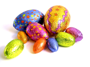 A collection of chocolate Easter eggs, wrapped individually in colored foil.