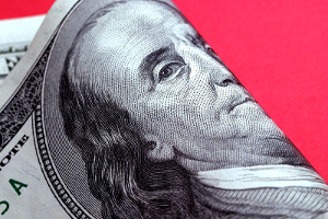 financial_literacy Close-up of the center of a folded $100 bill, set against a red background.