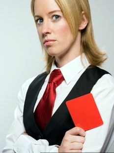 negotation_killer A businesswoman with crossed arms. She's holding a red card.