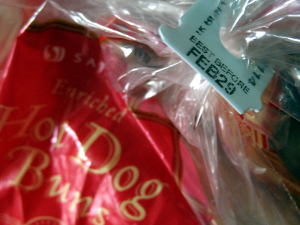 Close-up of the expiration date bag tie on a package of hot dog buns.