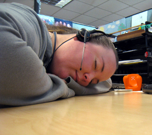 A call center worker asleep at her desk.