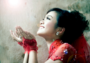 A happy woman looking upward. She appears hopeful.