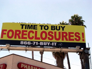 A billboard that reads “Time to buy foreclosures!”