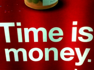time_is_money The words “Time is money” appear on a red tabletop.