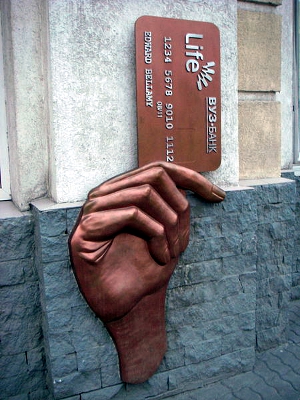 Sculpture of a hand holding a credit card.