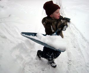 A young boy shoveling snow.