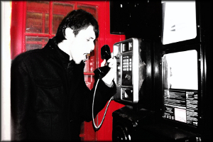 A man yelling while using a public telephone.