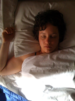 A young woman asleep in bed.