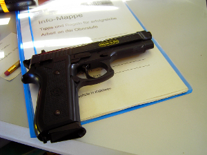 Today these imitation guns are forbidden in Germany. This one shoots small white bullets (about 2mm in diameter). It doesn't necessarily hurt when you are hit from a shot, but it's not completely non dangerous. There's a special sarcasm in this picture: The text on the paper below the weapon says "Hints for successful working at the upper stage school."